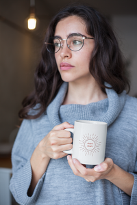 jeune femme qui réfléchit en tenant un Mug Constellation Verseau en céramique