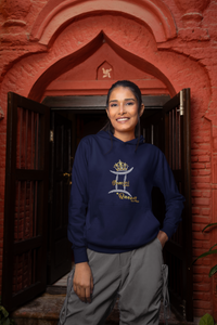 une femme souriante posant devant une porte vêtue d'un Sweat à capuche Golden Gemini Queen marine